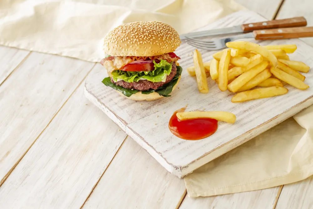 Burger mit Pommes frites auf einem Holzbrett